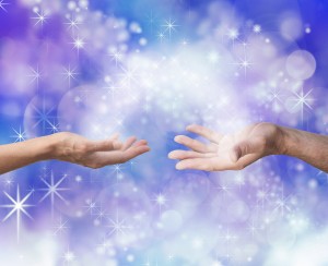 Man and woman both with one hand each palm up with an arc of white light and sparkles joining them on an electric blue colored energy formation background